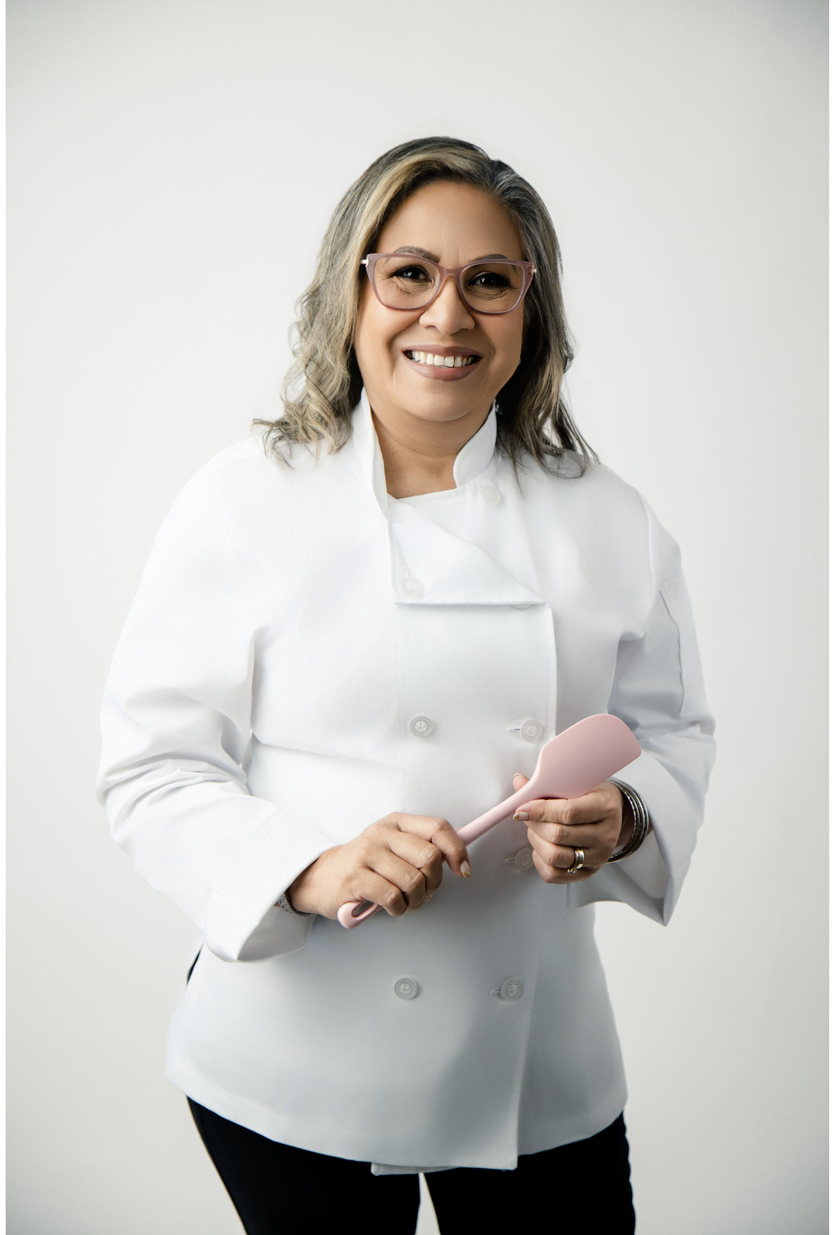 Helen, owner of Helen's Cupcake, smiling in a white blazer
